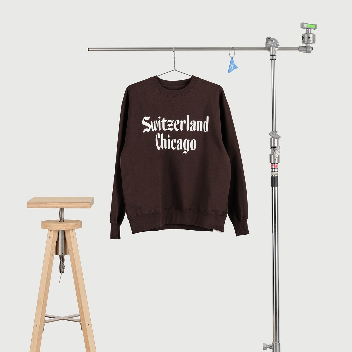 Brown Switzerland Chicago sweatshirt hanging in a studio
